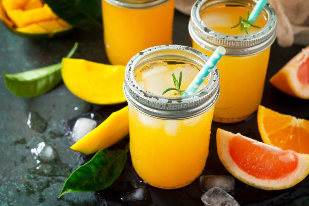 Inicio 5 Homemade refreshing fruit drink made of citrus and mango on a dark stone background.